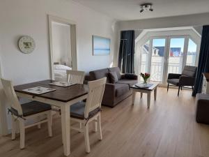 a living room with a table and chairs and a couch at Appartementhaus Hoppe in Sylt