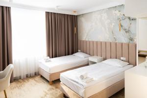 a hotel room with two beds and a painting on the wall at Hotel Przystań Przy Lesie in Lewiczyn +49 photos
