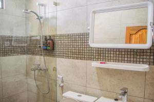 a bathroom with a shower and a toilet and a mirror at Shangani Hotel in Zanzibar City +21 photos