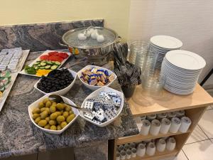 a buffet with plates and bowls of food on a counter at Brenzhotel Heidenheim in Heidenheim an der Brenz +29 photos