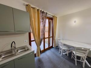 a kitchen and dining room with a table and a window at Ami Affittacamere 4 in Castel San Giovanni