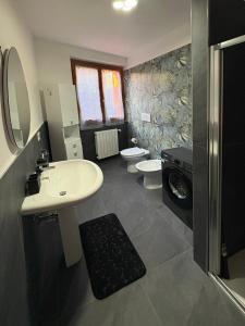 a bathroom with a sink and two toilets at Ami Affittacamere 4 in Castel San Giovanni