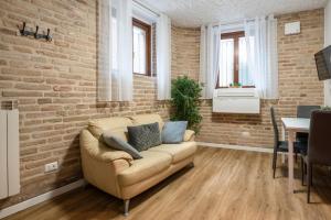 a living room with a couch and a brick wall at Maison all'Arco in Corridonia