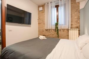 a bedroom with a bed and a flat screen tv at Maison all'Arco in Corridonia