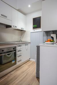 a kitchen with white cabinets and a bowl of fruit on the counter at Maison all'Arco in Corridonia