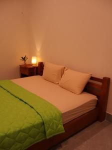 a bedroom with a bed with a green blanket on it at Green Haven Hill Phu Quoc in Phú Quốc