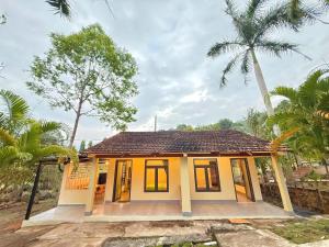 a small yellow house with a palm tree at Green Haven Hill Phu Quoc in Phú Quốc +7 photos