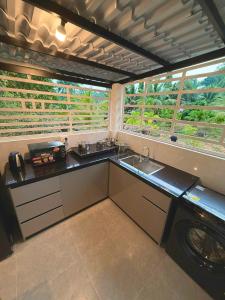 a kitchen with a sink and a washing machine at Green Haven Hill Phu Quoc in Phú Quốc
