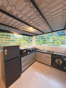 a kitchen with a sink and a washing machine at Green Haven Hill Phu Quoc in Phú Quốc