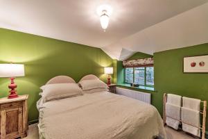 a green bedroom with a bed and a window at Finest Retreats - Dolhyfryd Lodge in Denbigh