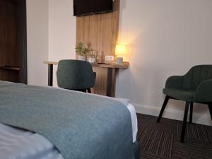 a hotel room with a bed and two chairs at Hotel Am Schwarzen Berg in Stade