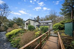 an exterior view of a house with a wooden bridge at Finest Retreats - Dolhyfryd Lodge in Denbigh
