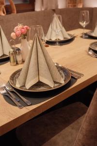a table with a plate with a napkin on it at Alpshotel Bergland in Pfelders