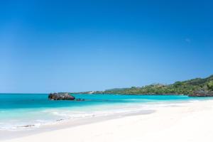 a beach with white sand and blue water at Casa mar in Las Galeras
