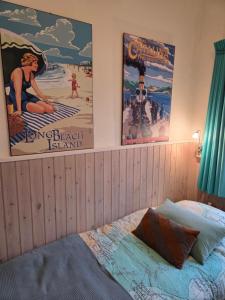 two posters on the wall of a bedroom with a bed at Riposo in West-Terschelling