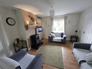 a living room with a couch and a fireplace at Cromlech Cottage in Portnoo