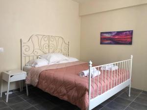 a bedroom with a bed with a white bed frame at Sidari High Street Apartment in Sidari