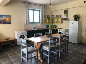 a kitchen with a table and chairs and a refrigerator at Sidari High Street Apartment in Sidari