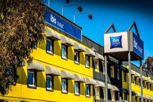 een geel gebouw met een busdepot erop bij ibis Budget - Fawkner in Melbourne