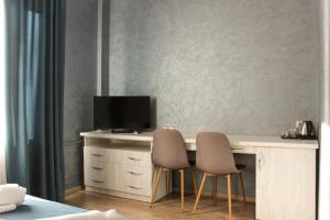 a desk with two chairs and a television on it at Rivne Hostel in Rivne