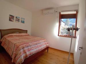 a bedroom with a bed and a window at Casa Vacanze Minù in Faggeto Lario 