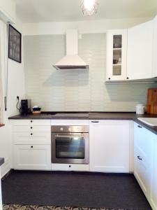 a kitchen with white cabinets and a stainless steel oven at Casa Vacanze Minù in Faggeto Lario  +21 photos