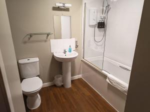 a bathroom with a toilet and a sink and a shower at Chieftain Hotel in Inverness +56 photos