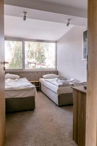 two beds in a room with a window at Imperiall Resort&MediSPA-DOMKI PREMIUM in Sianozety +56 photos