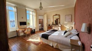 a bedroom with a large bed and a mirror at Château Pontet d'Eyrans & Spa in Eyrans-de Soudiac