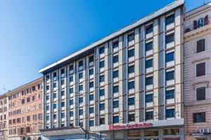 a large building with a sign on the side of it at Hilton Garden Inn Rome Colosseum in Rome