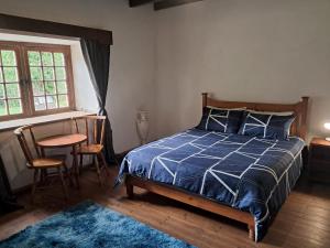 a bedroom with a blue bed and a table and chairs at Klipfontein Rustic Farm & Camping in Tulbagh +77 photos