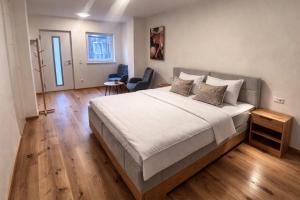 a bedroom with a large bed with a wooden floor at Nous Cafe & Restaurant in Krumnussbaum