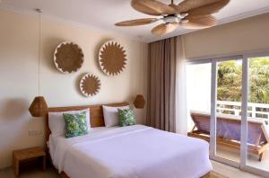 a bedroom with a bed and a ceiling fan at Cocoon Self-Catering Apartments in Anse a La Mouche