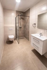 a bathroom with a shower and a toilet and a sink at Nous Cafe & Restaurant in Krumnussbaum