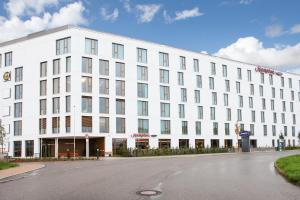 a white building with a street in front of it at Hampton By Hilton Stuttgart Airport in Filderstadt