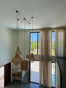 a room with two chandeliers and a large window at Anba Solēy in Surinam