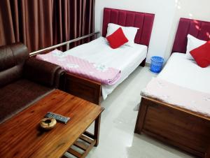 a room with two beds and a couch and a table at Hotel Dhanmondi Prime in Dhaka
