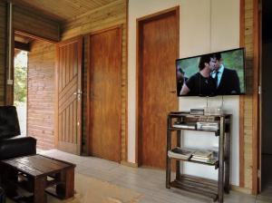 a living room with a flat screen tv on a wall at Casa De Praia Galheta in Farol de Santa Marta