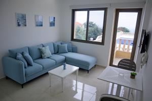 a living room with a blue couch and a table at Villa Olivera Hotel in Tḩūm at Taḩtā