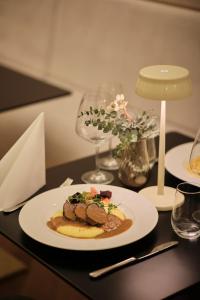 a plate of food on a table with a glass at Palatinus Grand Hotel in Pécs