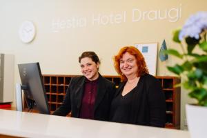 two women sitting at a desk in front of a computer at Hestia Hotel Draugi in Riga