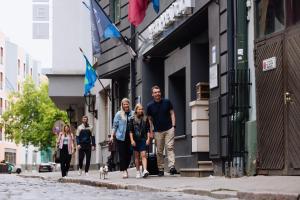 a group of people walking down a street at Hestia Hotel Draugi in Riga
