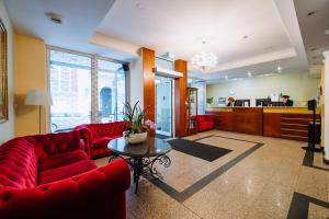 a living room with red couches and a table at Hestia Hotel Draugi in Riga