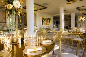 ein Restaurant mit Tischen, Stühlen und Blumen in der Unterkunft Hotel Aurelia in Timişoara