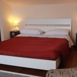 a bedroom with a white bed with a red blanket at B & B Paradiso in Loreto