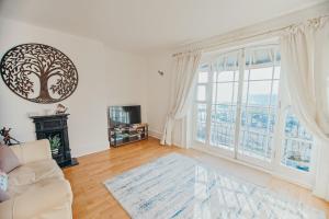 a living room with a couch and a large window at The Pelham Penthouse in Hastings +24 photos
