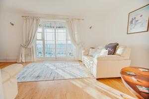 a living room with a couch and a large window at The Pelham Penthouse in Hastings