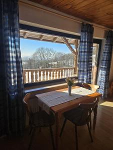 a table and chairs in a room with a window at Pension Haus Donaublick in Deggendorf
