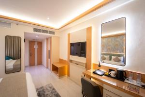 a hotel room with a bed and a television at Smana Hotel Al Raffa in Dubai