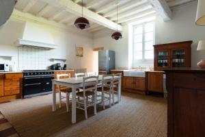 a kitchen with a table and some chairs in it at Beaulieu Saint Come in Saint-Côme